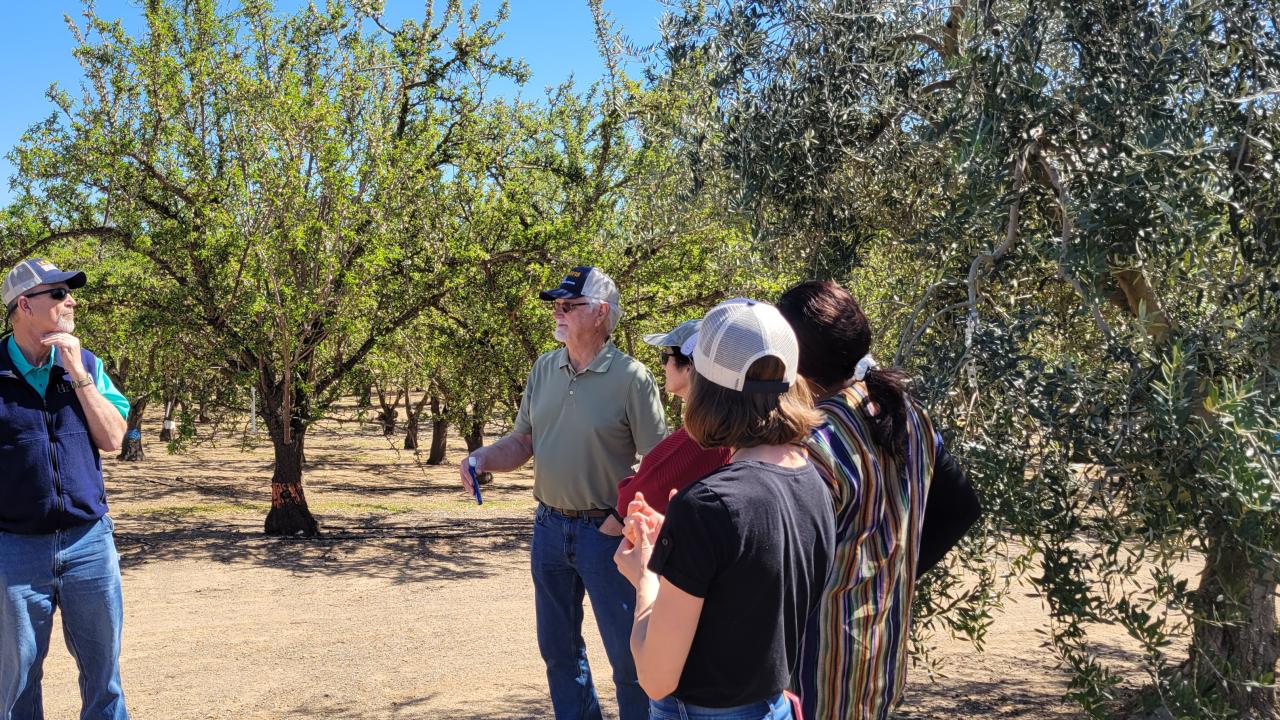Principles attendees listening to Franz Niederholzer in the field.
