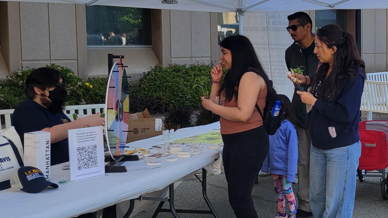 Image of Picnic Day attendees visiting the Fruit and Nut Research and Information Center booth.