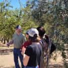 Principles attendees listening to Franz Niederholzer in the field.