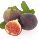 Two figs and a slice of fig on leaves.