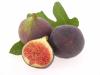 Two figs and a slice of fig on leaves.