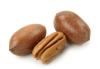 A pecan next to two pecan shells.